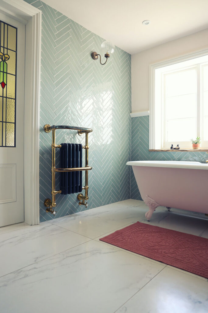 Bathroom with large white tile flooring and chevron green tiled walls