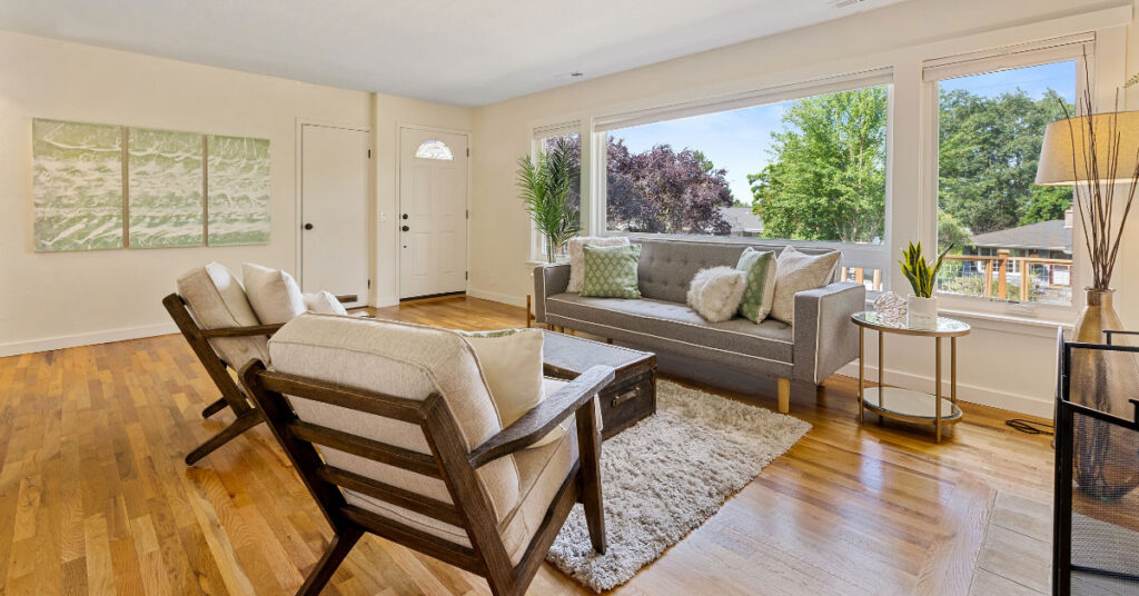 Blonde color hardwood flooring in living room with large windows