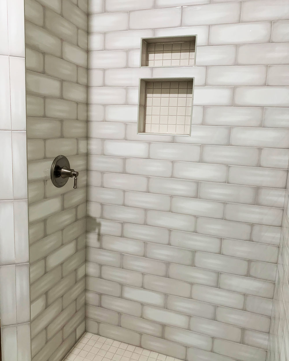 Bathroom shower wall with grey tiles