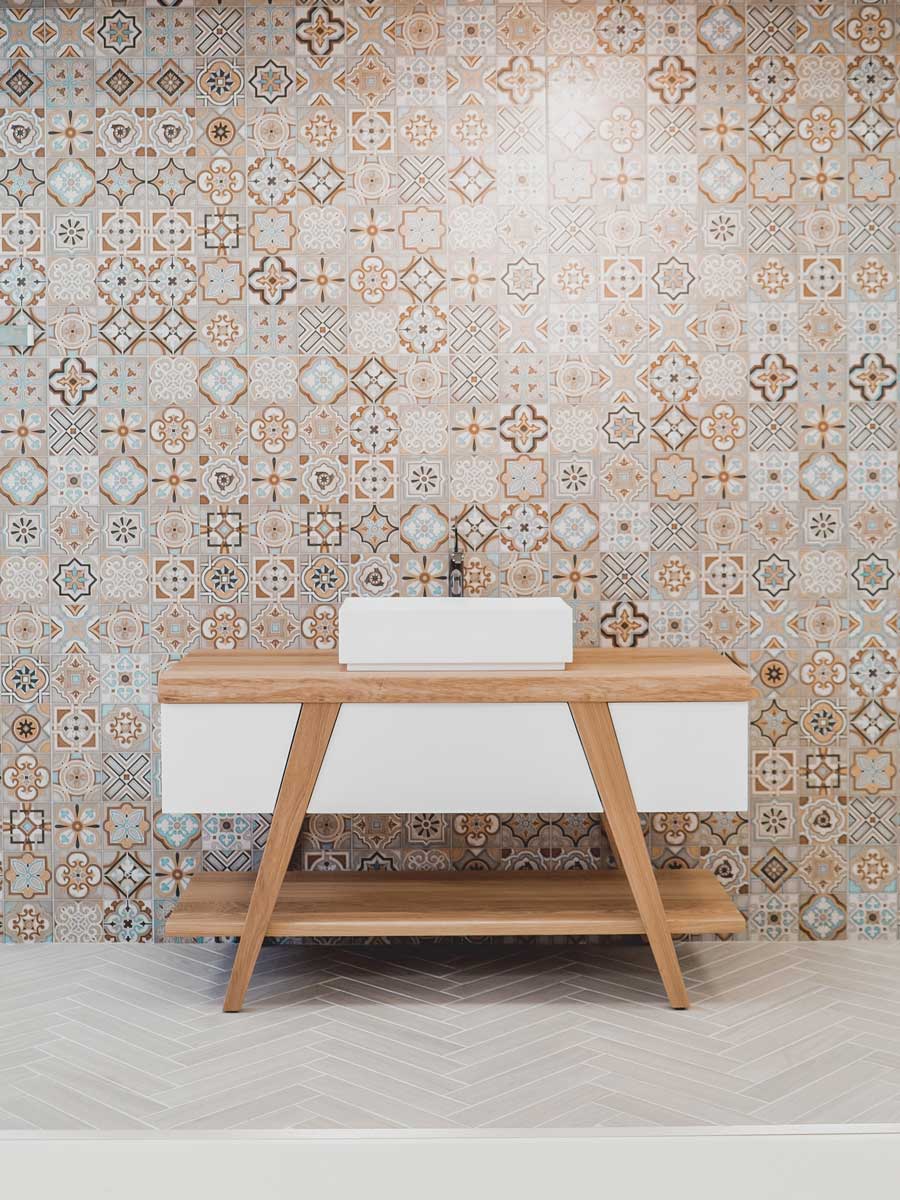 Mosaic tiled bathroom with patterned walls and chevron floor tiles
